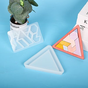 May include: Two silicone molds for resin casting. One mold is a rectangle with a geometric pattern. The other mold is a triangle.
