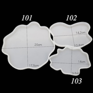 Puede incluir: Tres moldes de resina blanca translúcida de formas irregulares, para manualidades. El más grande mide 20 cm de ancho, el mediano 14,2 cm y el más pequeño 14 cm. Cada molde está etiquetado con un número: 101, 102 y 103.