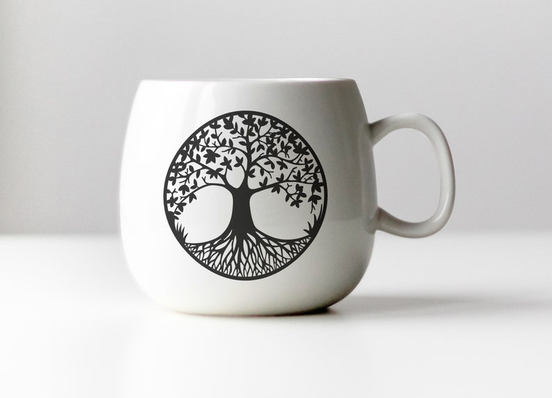 May include: White ceramic mug with a black tree of life design. The tree has intricate branches and roots.