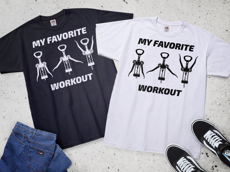 May include: Two t-shirts with a graphic of three corkscrews and the text "My Favorite Workout". One t-shirt is black with white text and graphics, and the other is white with black text and graphics.