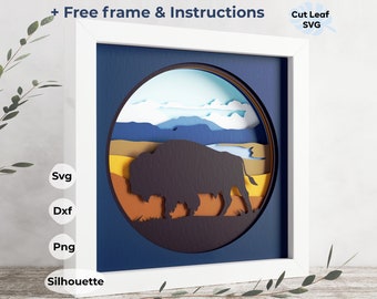 Puede incluir: Un marco blanco con fondo azul y un diseño de corte de papel en capas de un bisonte en un paisaje. El diseño incluye un esquema de color amarillo, naranja, marrón y azul. El texto "Free frame & Instructions" está en la parte superior de la imagen. El texto "Cut Leaf SVG" está en la parte superior derecha de la imagen.