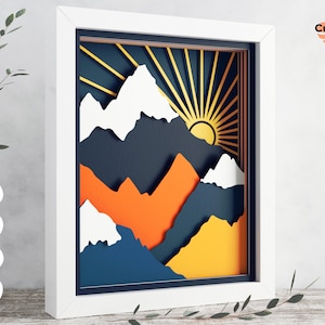 Peut inclure: Un fichier numérique pour un design d'artisanat en papier superposé représentant une chaîne de montagnes avec un soleil se levant derrière elle. Les montagnes sont dans des tons de bleu, d'orange et de jaune. Le soleil est jaune avec des rayons orange.