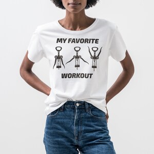 May include: White t-shirt with a graphic of three corkscrews and the text "My Favorite Workout".