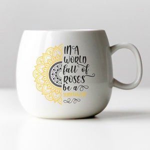 May include: White ceramic mug with a yellow and black mandala design and the text "In a world full of roses be a sunflower".