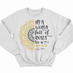 May include: White sweatshirt with a gold and black mandala design and the text "In a world full of roses be a sunflower".