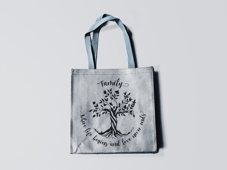 May include: A gray tote bag with blue handles features a black silhouette of a tree with the text "Family where life begins and love never ends".