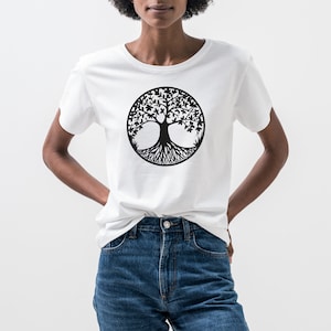 May include: A white t-shirt with a black tree of life design on the front. The tree is stylized with intricate roots and branches.