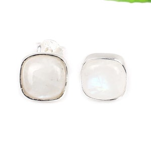Puede incluir: Un par de pendientes de plata con piedras de luna de forma cuadrada.