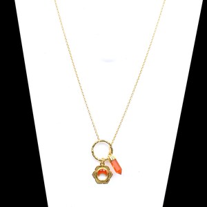 May include: Gold necklace with a small orange gemstone pendant and a gold charm with a flower design.