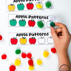 May include: A set of three printable apple pattern cards with the words "Apple Patterns" at the top of each card. The cards feature different colored apples, including red, green, yellow, and white. The cards are designed for children to learn about patterns and colors.