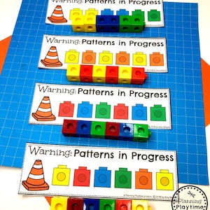 May include: Four printable cards with the text "Warning: Patterns in Progress" and a traffic cone icon. Each card has a different pattern of colored blocks, with the blocks arranged in a line.