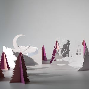 K&ouml;nnte beinhalten: Ein Papier-Diorama einer Winterlandschaft mit einem Halbmond, Wolken und silhouettierten H&auml;usern und B&auml;umen. Die B&auml;ume sind wei&szlig; und rosa, wodurch ein geschichteter Effekt entsteht. Die Szene ist vor einem hellgrauen Hintergrund.
