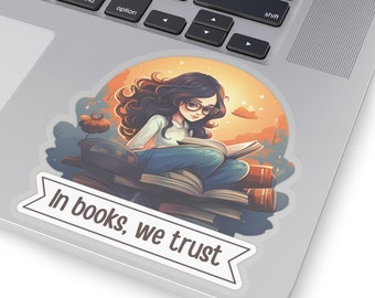 Può includere: Un adesivo con un'illustrazione di cartone animato di una ragazza che legge un libro mentre è seduta su una pila di libri. Lo sfondo è un tramonto con stelle e un disco volante. L'adesivo ha il testo "In books, we trust" su uno striscione.