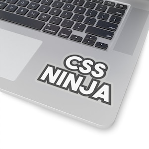 Op de afbeelding: Een witte sticker met zwarte tekst die "CSS NINJA" zegt op een zilveren laptop.