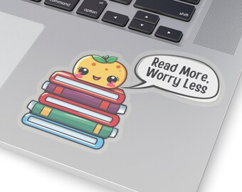 May include: A sticker with a cute cartoon orange on a stack of books. The orange has a happy face and is wearing a green leaf. The sticker also includes the text "Read More, Worry Less".