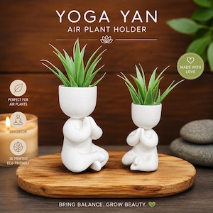 May include: Two white, matte-finish, 3D-printed air plant holders shaped like figures in a seated yoga pose with hands pressed together. Each figure holds a green, spiky air plant. The text reads YOGA YAN AIR PLANT HOLDER and BRING BALANCE. GROW BEAUTY.