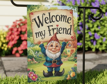 May include: A garden flag with a cartoon gnome holding a sign that says "Welcome my Friend". The gnome is wearing a blue and red outfit and a red hat. The flag is surrounded by flowers and greenery.