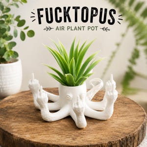 May include: A white octopus-shaped air plant pot featuring multiple tentacles, each raised to display a middle finger gesture. The text FUCKTOPUS AIR PLANT POT is printed above the object in a bold, black, hand-drawn style font.