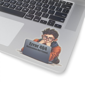 May include: A sticker featuring a cartoon illustration of a person sitting at a laptop with the text "Error 404 Motivation Not Found."