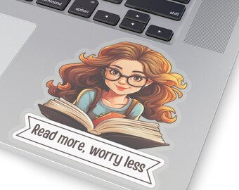Può includere: Un adesivo con una ragazza dei cartoni animati con i capelli castani e gli occhiali che legge un libro. L'adesivo ha uno striscione in basso che dice "Leggi di più, preoccuparti di meno."