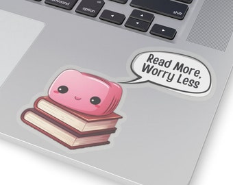 May include: A pink cartoon character with a happy face is sitting on top of a stack of two books. The character is wearing a speech bubble that says "Read More, Worry Less".