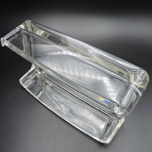 Op de afbeelding: Een rechthoekige schaal van helder glas met een verhoogd gedeelte in het midden. De schaal is gemaakt van dik glas en heeft een gladde, gepolijste afwerking.