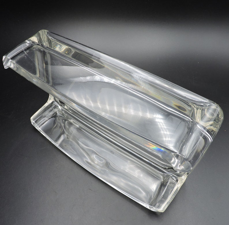 Op de afbeelding: Een rechthoekige schaal van helder glas met een verhoogd gedeelte in het midden. De schaal is gemaakt van dik glas en heeft een gladde, gepolijste afwerking.
