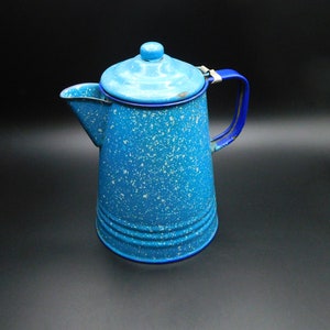 May include: A blue enamel coffee pot with a white speckled design and a blue handle.