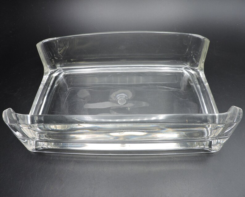 Op de afbeelding: Een rechthoekige, transparante plastic schaal met een verhoogde rand en een gladde, vlakke bodem. De schaal is ontworpen om kleine voorwerpen in te bewaren, zoals sieraden of andere snuisterijen.