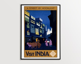 May include: A vintage travel poster advertising a visit to India. The poster features a colorful illustration of a street scene at night with buildings, people, and a cart pulled by oxen. The text on the poster reads "A Street by Moonlight" and "Visit India".