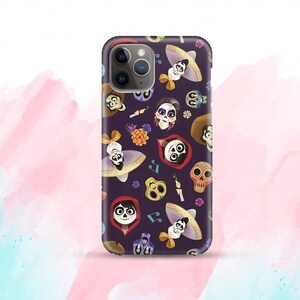 May include: A purple phone case with a repeating pattern of characters from the movie Coco. The characters include Miguel, Hector, and Dante. The case also features musical notes, flowers, and skulls.