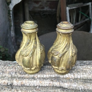 Puede incluir: Dos pies de muebles de metal de color dorado adornados con un diseño detallado y en espiral.