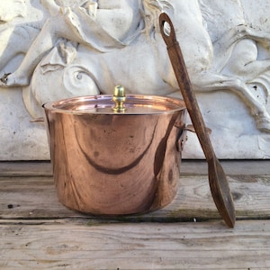 Cacerola pequeña de cobre. Utensilio de cocina antiguo, rústico y artesanal, con tapa y mango de latón. Decoración rústica de estilo rústico.