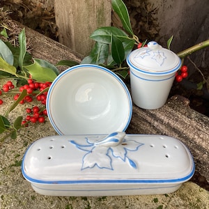 Peut inclure: Un ensemble de trois plats en céramique blanche avec une bordure bleue. Les plats présentent un motif floral et sont parfaits pour servir de petites collations ou des desserts.