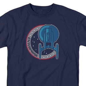May include: A navy blue t-shirt with a white, red, and blue starfleet emblem featuring a spaceship and the word "ENTERPRISE".