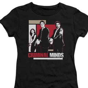 May include: Black t-shirt with a white and red graphic of three people from the TV show "Criminal Minds". The text "Criminal Minds" is printed in white on a red background.
