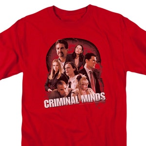 May include: Red t-shirt with a graphic of the cast of the TV show "Criminal Minds". The graphic features the main characters in a group shot with a red background.