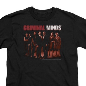 May include: Black t-shirt with a red and white graphic of the text "CRIMINAL MINDS" and a group of people in silhouette.