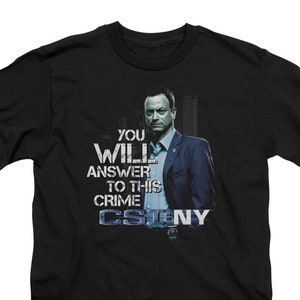 May include: Black t-shirt with a graphic of a man in a suit and the text "You Will Answer To This Crime CSI:NY".