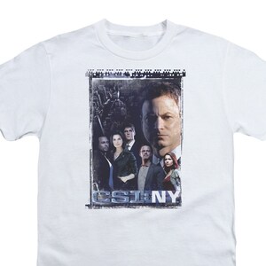 May include: White t-shirt with a graphic of the cast of CSI: NY. The graphic is in a distressed style and features the show's logo.