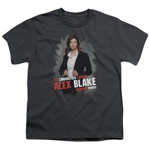 May include: A dark gray t-shirt with a graphic of a woman in a black suit and white shirt. The text "FBI Linguistics Expert Alex Blake Criminal Minds" is printed in red on the shirt.