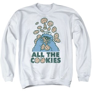 May include: White long-sleeved sweatshirt with a blue Cookie Monster graphic and the text "All the Cookies".