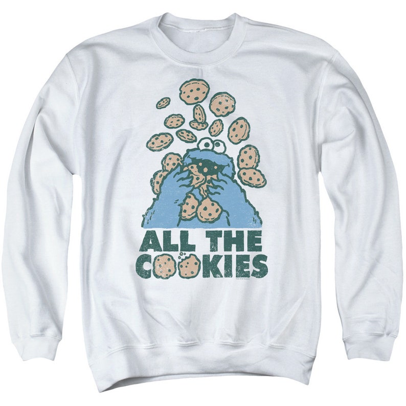 May include: White long-sleeved sweatshirt with a blue Cookie Monster graphic and the text "All the Cookies".