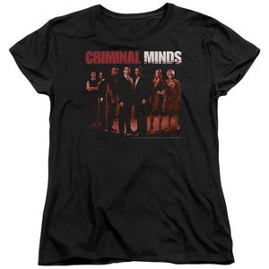 May include: Black t-shirt with a red graphic of the text "CRIMINAL MINDS" and a group of people in front of a red background.