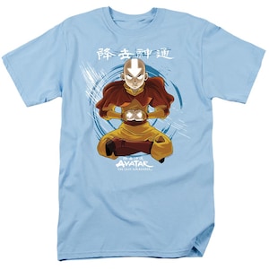 May include: A light blue t-shirt featuring an illustration of Avatar Aang meditating in a blue and white swirling pattern. The text "Avatar: The Last Airbender" is printed below the image. The Chinese characters "静止中神通" are printed above the image.
