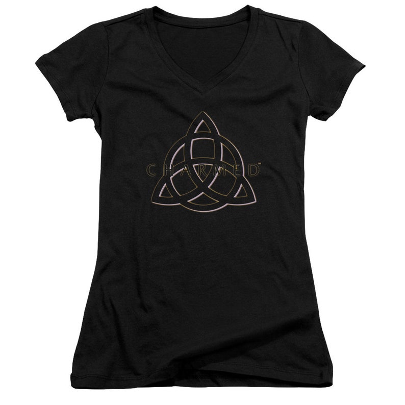 Op de afbeelding: Zwart V-hals T-shirt met een gouden en roze omtrek van het "Charmed" symbool, een driepuntige ster met een cirkel in het midden.