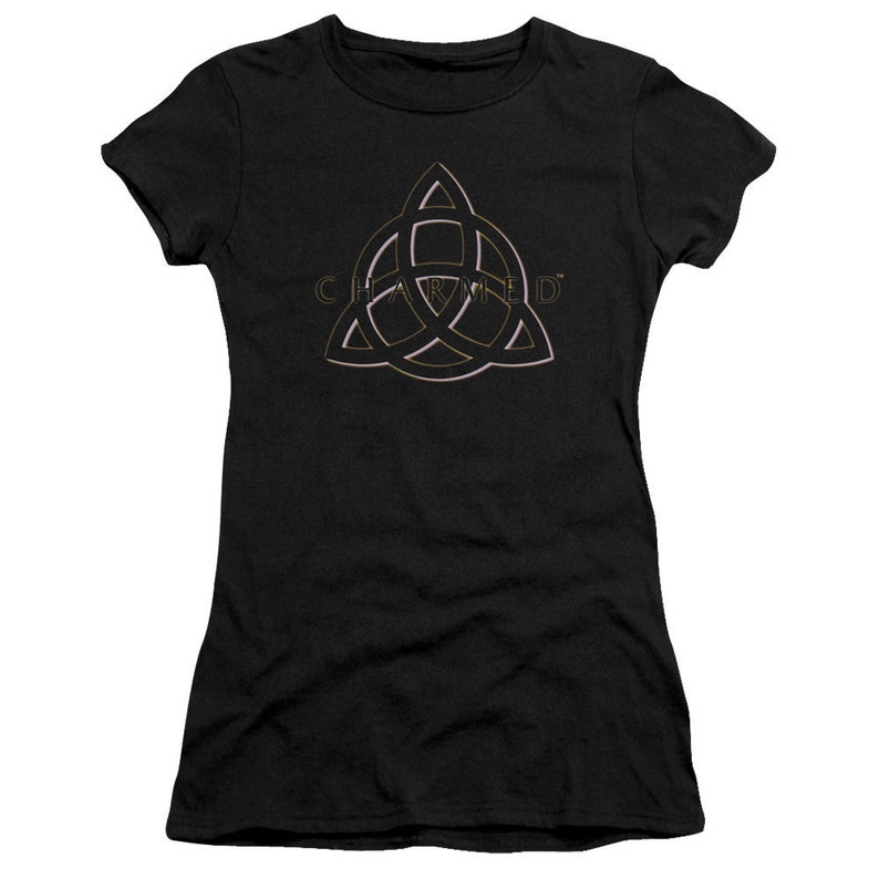Op de afbeelding: Zwart T-shirt met een gouden en roze omtrek van een driepuntige ster met het woord "CHARMED" erin.