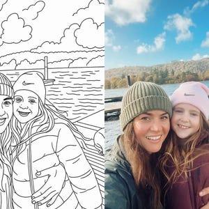 May include: Two people wearing knitted hats are smiling at the camera. The person on the left is wearing a grey hat and the person on the right is wearing a pink hat. They are standing in front of a body of water with a cloudy sky in the background.