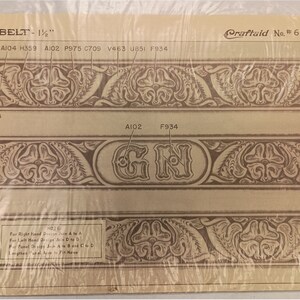 May include: A beige Craftaid No. 6550 belt pattern template measuring 1.5 inches wide. The sheet features brown floral tooling designs, letter codes, and the letters GN. It includes assembly instructions for joining panels and is encased in plastic.
