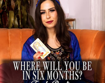 May include: A woman wearing a blue and gold robe holds a tarot card in front of an orange sofa. The text on the image reads "Where will you be in six months? Tarot Reading."